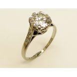An elegant and desirable 8 claw Rex setting Pave set Ring, with a central round brilliant 2ct,