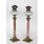 A pair of Victorian Oil Lamps, with marble and ormolu Corinthian column pillars and glass bowls,