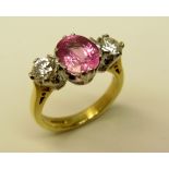 An attractive "Pink" sapphire Ring, with two diamonds, the central oval pink sapphire (1.
