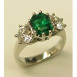 An elegant three stone Ring, set with emerald cut "Emerald" (.6ct) and two round diamonds (.