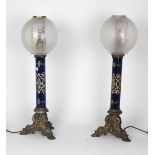 An attractive pair of Regency Oil Lamps, with enamelled blue glass columns and ormolu rococo bases,