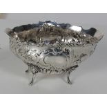 An oval bath shaped silver Bowl, with extensive repousse decoration of scrolls,