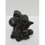 A heavy 19th Century Japanese bronze Figure of rotund Japanese Man, Hotri, seated with a backpack,