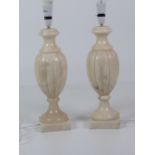 A pair of urn shaped marble Lamps, with shades.