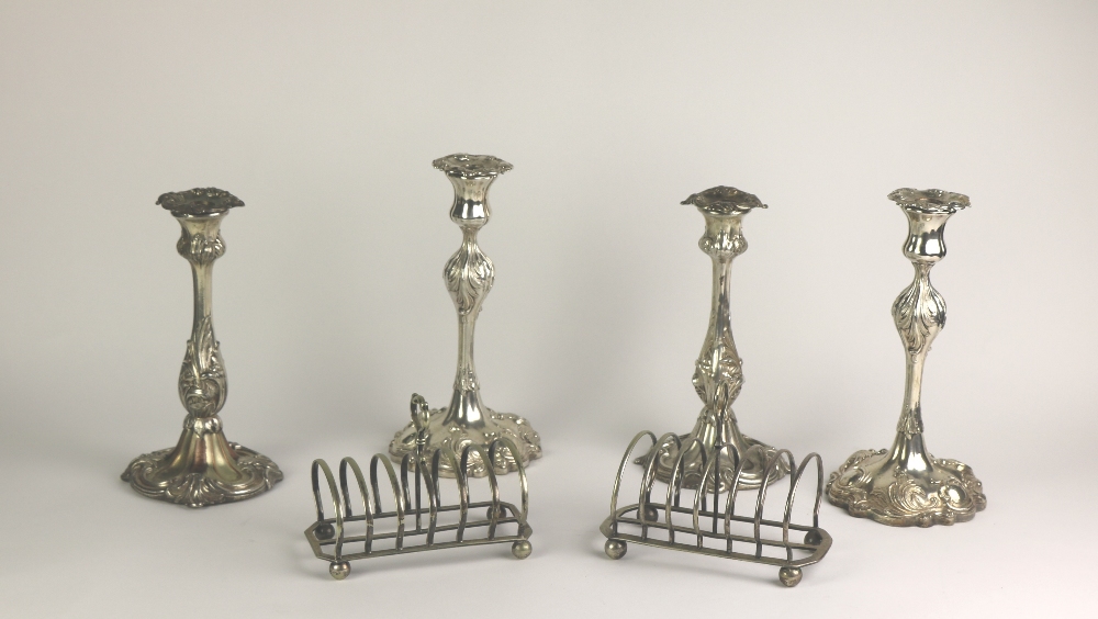 Plateware: A box containing two pairs of plated Candlesticks, , two Toast Racks, silver plated Mugs,