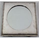 A very attractive oval silver Table Mirror, by William Comyns, London 1902, with rectangular frame,