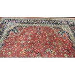 A large claret ground Carpet, with central decorated panel,