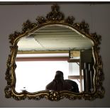 A French style Overmantel, with carved floral decorated border and shaped inset mirror, approx.