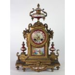 An attractive gilt bronze and porcelain Mantle Clock, with two handled urn surmounted,