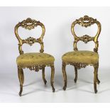 A pair of French gilt Salon Side Chairs, covered in gold damask fabric.