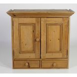 A small hanging pine Cupboard, with moulded cornice, two panel doors and two drawers,