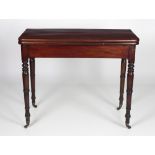 A plain Irish 19th Century mahogany fold-over Tea Table, on turned tapering legs with brass castors,