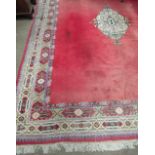 A large burgundy ground Oriental Carpet, with plain centre and decorative floral pattern border,