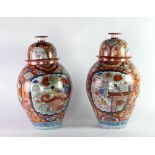 A pair of almost matching 19th Century Japanese Imari orange ground large bulbous Vases and lids,