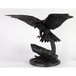 An attractive assimilated bronze model of a Falcon, coming to rest on a branch,