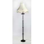 A tall 19th Century wrought iron Candle Holder, converted as lamp stand, with cream shade.