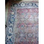 A 19th Century red ground Oriental Carpet, with floral centre and large blue ground border,