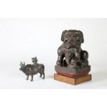 An early carved wooden cinnabar type Chinese Figure, modelled as a dog of Foo with pup,