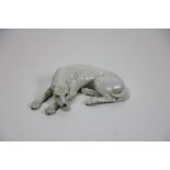 A 19th Century French porcelain Figure of a reclining hound with painted eyes and nose, 5" (12.