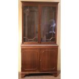 A small Georgian style wooden Bookcase, with two glazed doors, on bracket feet.