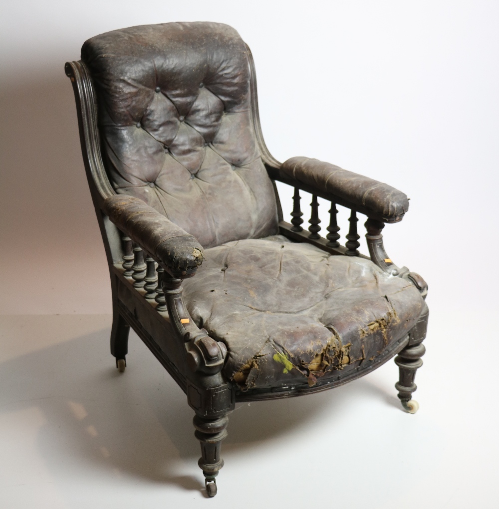 A carved Edwardian walnut Library Armchair, covered in hide.