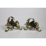 A pair of French bronze and gilt bronze Chenets, each in the rococo style with cherubs,