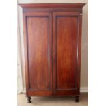 A Victorian mahogany Wardrobe, with plain cornice over moulded panel doors on turned front feet,