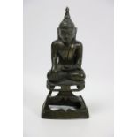 An early bronze Figure of a seated Buddha, on an openwork seat, showing traces of gilt, 7" (18cms).