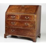 A Georgian period mahogany drop front Bureau, with fitted interior, over a base on bracket feet,