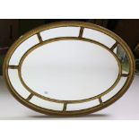 An attractive Regency style oval compartmental gilt Mirror,