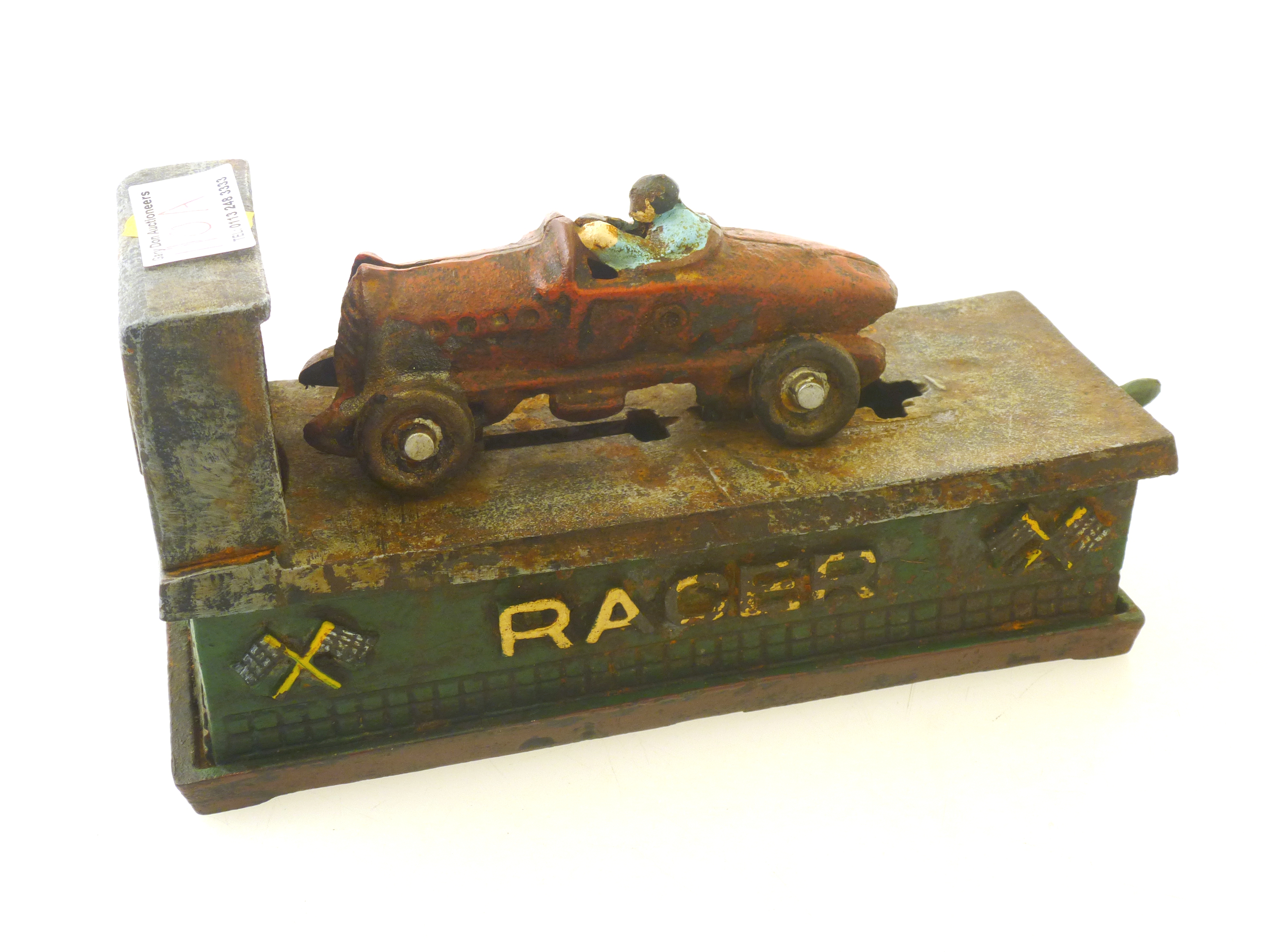 A GOOD 1920S CAST IORN AND PAINTED 'RACER' MONEY BOX, MOUNTED WITH A BUGATTI AND DRIVER, ON SPRING