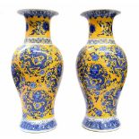 Pair of contemporary Chinese porcelain baluster cases, decorated with blue dragons and orchids