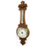 Oak aneroid barometer/thermometer, the 8" cream dial within a foliate carved case