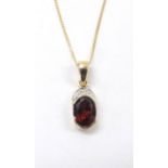 9ct diamond and garnet pendant on a slender trace chain, the pendant 16mm
