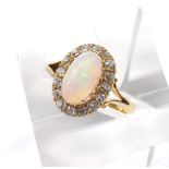 Attractive opal and diamond oval cluster ring in a yellow gold setting, the cabouchon opal in a