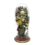 Victorian arrangement of flowers, within a slender baluster ruby and cut clear glass vase, under a