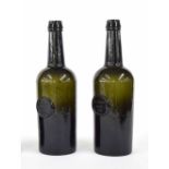 Pair of 18th century green glass wine bottles, each set with circular seals for W. Leman, Chard