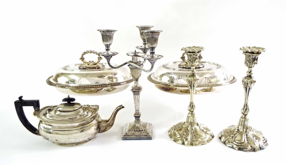 Silver plated ware, to include a pair of lidded entree dishes, pair of candlesticks, a centrepiece