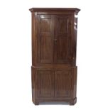 Mahogany corner cupboard, the moulded cornice over twin blind panelled doors enclosing a shelved