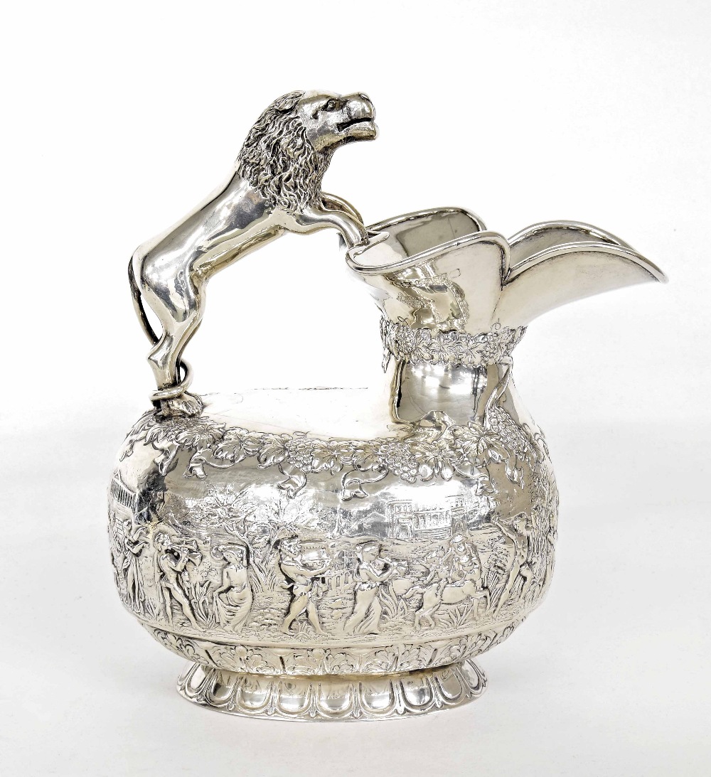 Edwardian silver jug with lion handle, of oval form repousse with a band of parading figures in a