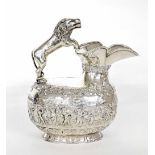 Edwardian silver jug with lion handle, of oval form repousse with a band of parading figures in a