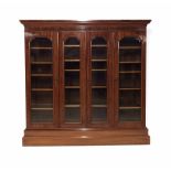 Good large Victorian mahogany glazed library bookcase, the scratch carved cornice over four glazed