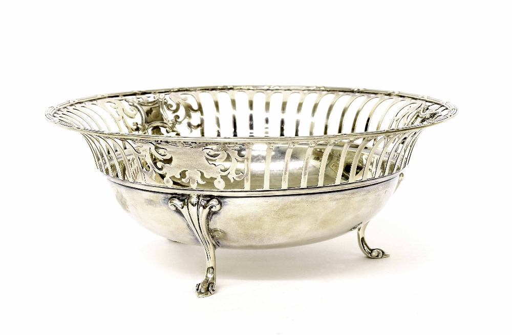 George V circular silver basket with a pierced rim upon three scroll feet, maker James Dixon &