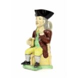 19th century pearlware Staffordshire Toby jug, modelled as a seated gentleman in a brown coat