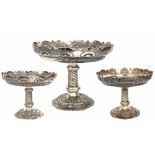 Late Victorian silver comport table garniture, with card-cut rims with shell motifs, over embossed