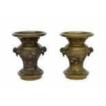 Pair of small Chinese bronze twin-handled vases, cast in relief with panels of buddhistic lions