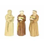 Three similar Royal Worcester porcelain candle snuffers modelled as monks, each with puce factory