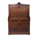 Arts & Crafts style pitch pine bureau, the raised shelved back over a vertical fall front carved