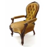 Victorian walnut spoon back upholstered armchair, with gold button-back upholstery, the frame carved