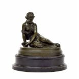 After Clodion - bronze modelled as a seated maiden holding a clam shell upon an oval stepped base,